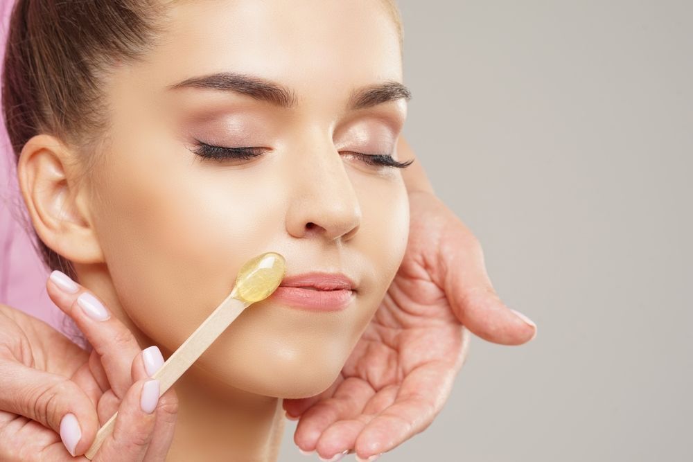 A woman is getting her face waxed in a beauty salon.
