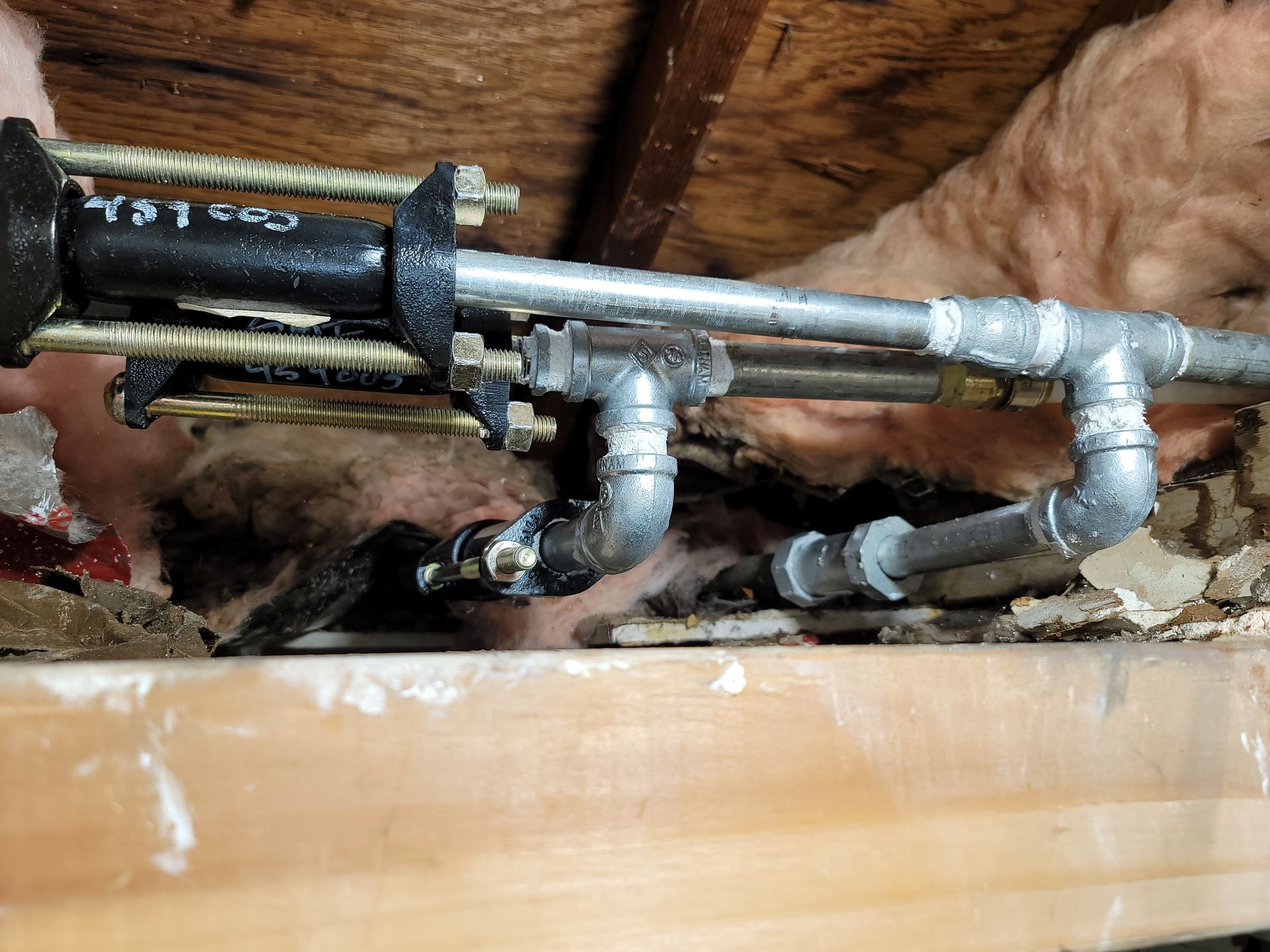 A person is fixing a pipe with a wrench.