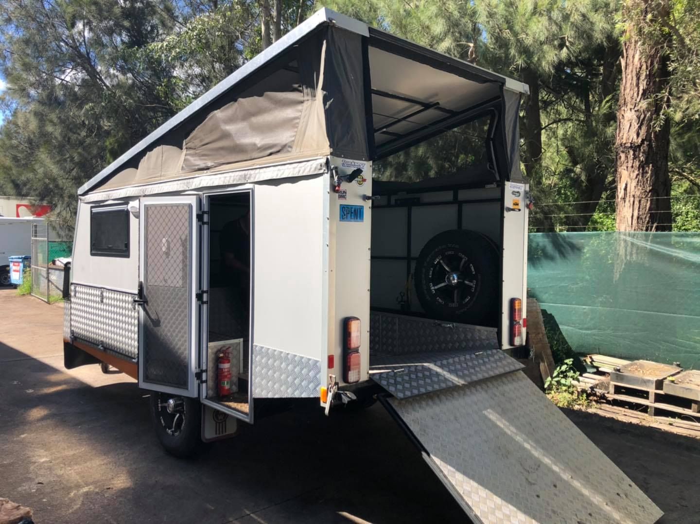 A White Trailer With a Ramp Attached to It is Parked in a Parking Lot — Truckserv In Kiama, NSW