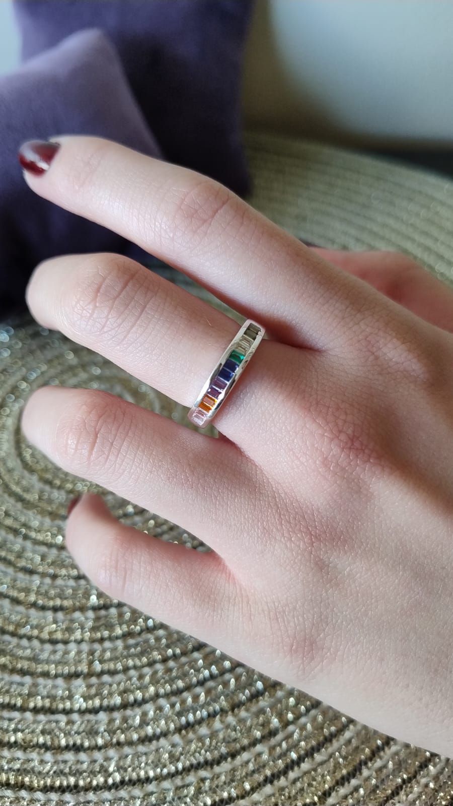 Una persona lleva un anillo de color arcoíris en su dedo.