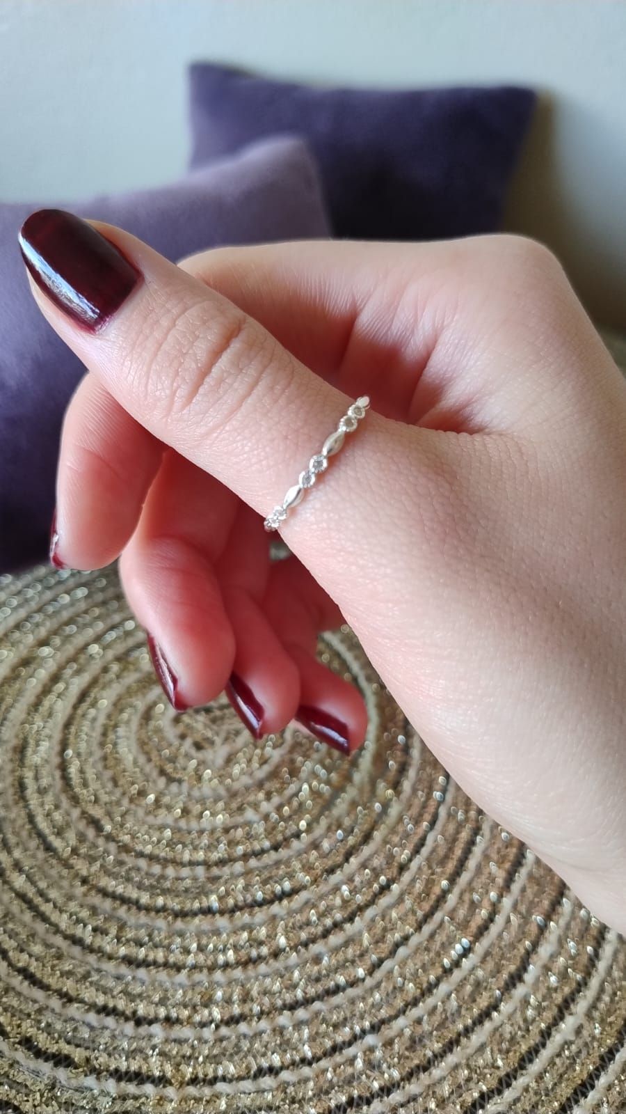 Una persona sostiene un anillo de plata en su dedo.