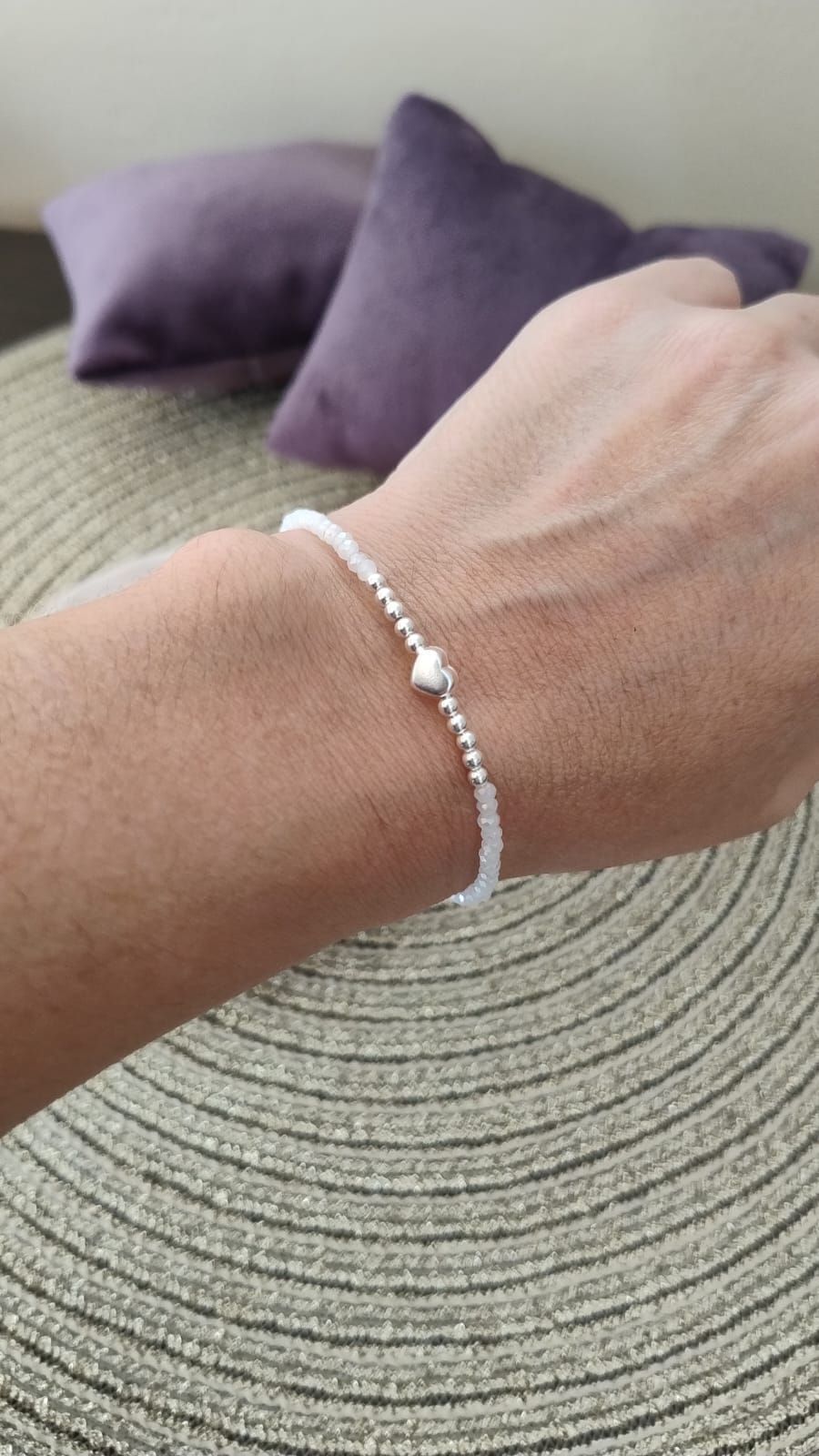 Una persona lleva una pulsera con un corazón en su muñeca.