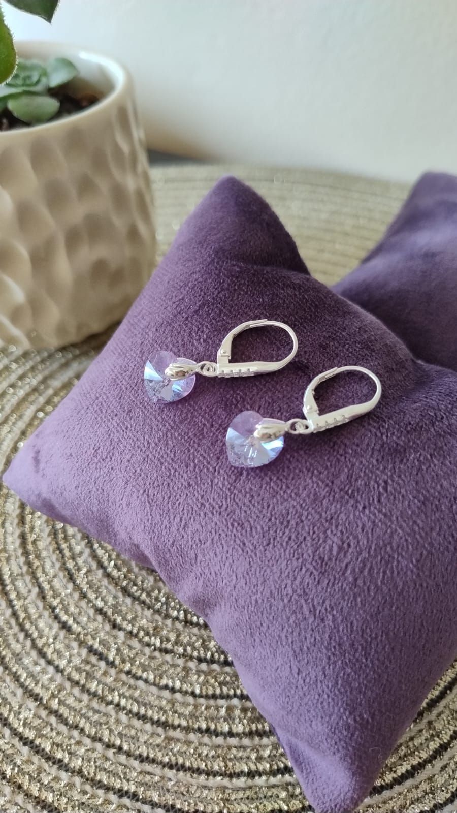 Un par de pendientes descansan sobre una almohada morada.