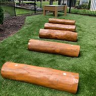 A row of logs sitting on top of a lush green field.