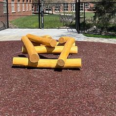 A pile of logs stacked on top of each other on a playground.