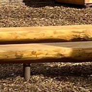 A wooden bench is sitting on top of a pile of wood chips.