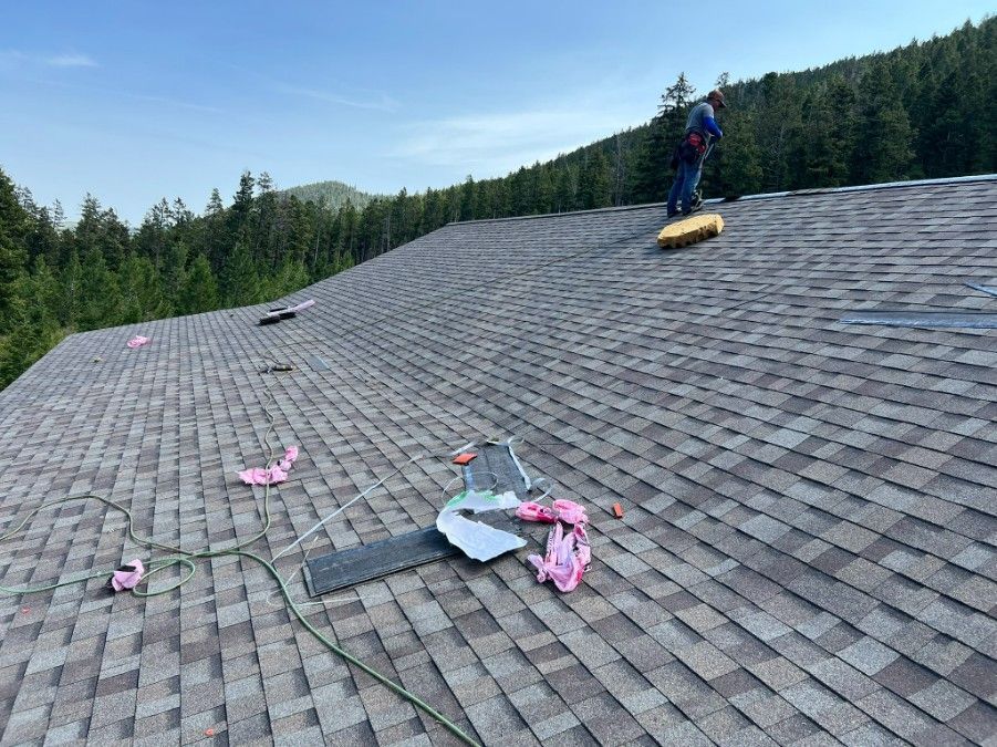 Woman in straw hat smiles, holding wine glass near a lake.