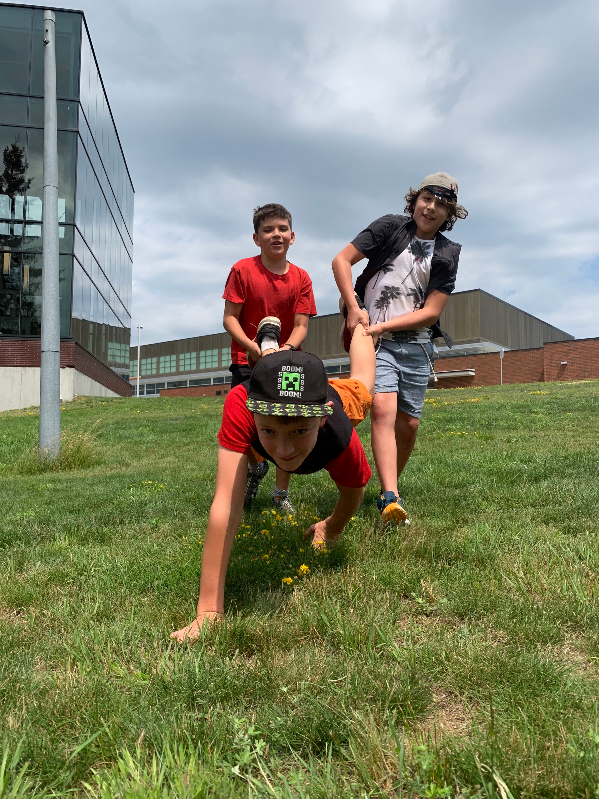A group of young boys are sitting on the grass together.