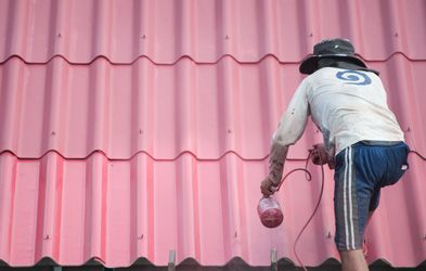 Man Paint Roof Using Spray Paint — Painters in Parkes