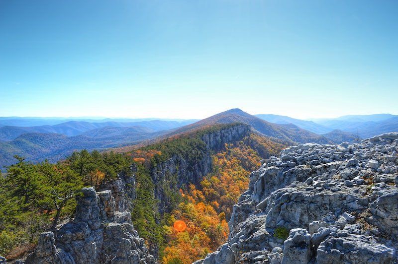 A view of a mountain range from the top of a rocky cliff.