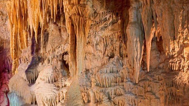 A cave with a lot of icicles hanging from the ceiling.