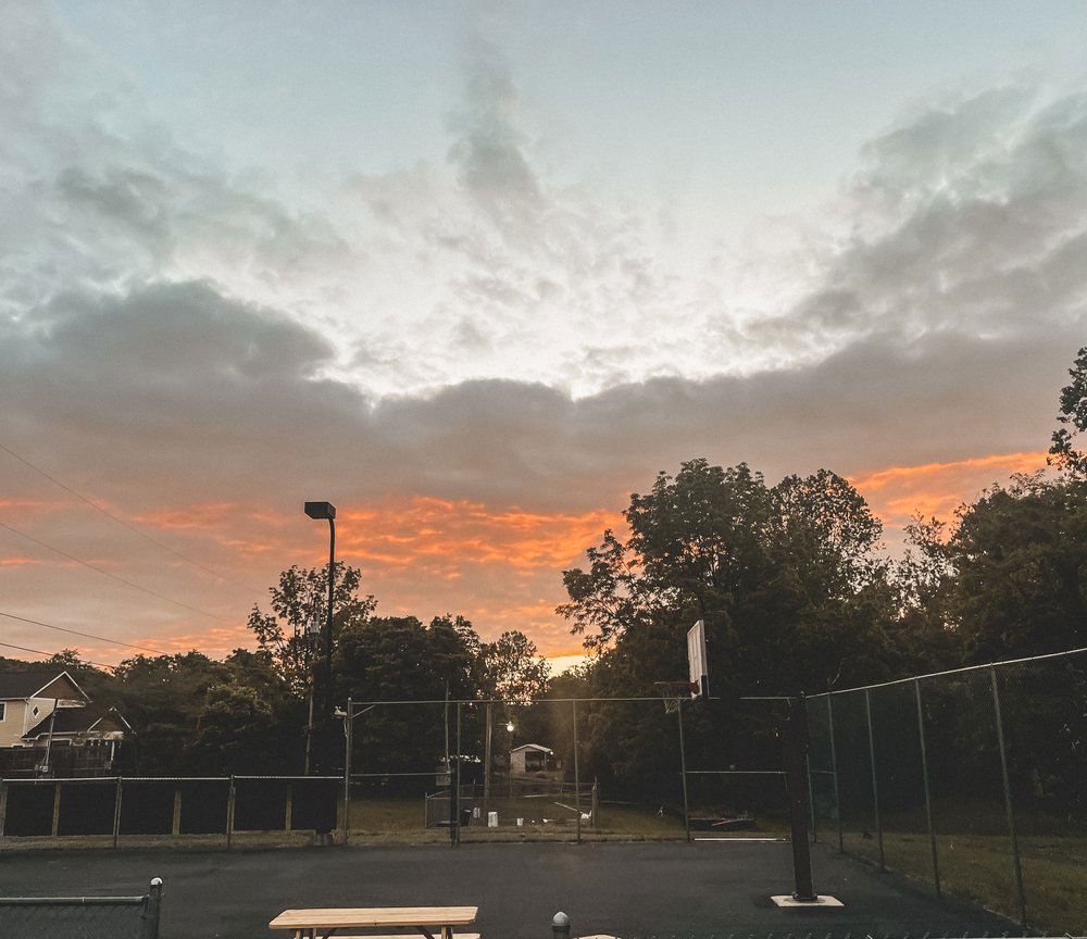 A basketball court with a sunset in the background