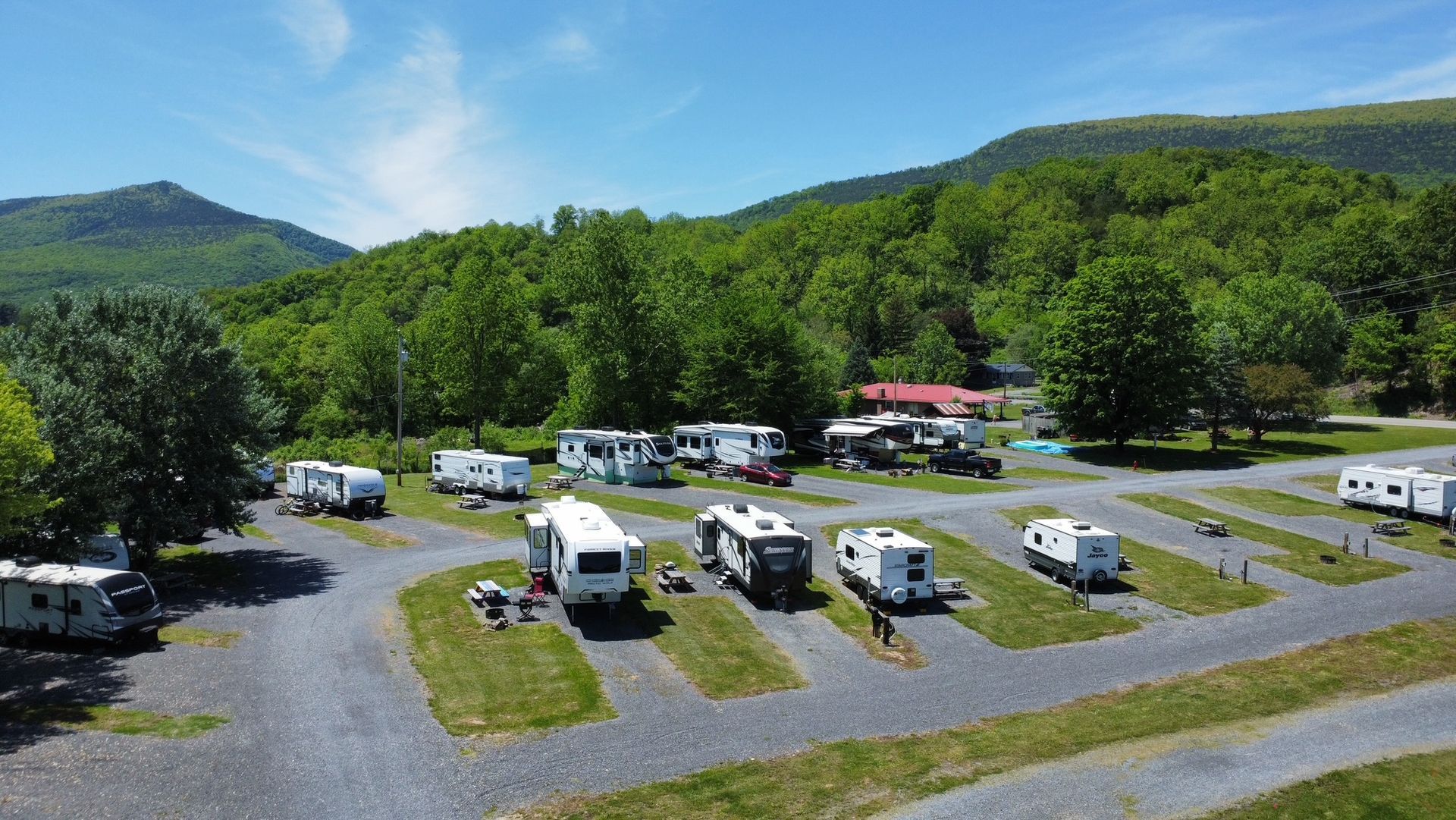 An aerial view of a rv park with mountains in the background.