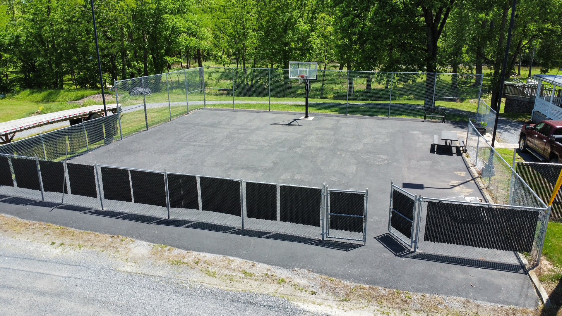 An aerial view of a basketball court surrounded by a chain link fence.