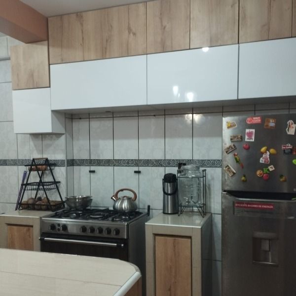 Una cocina con un horno de estufa y un refrigerador con imanes.