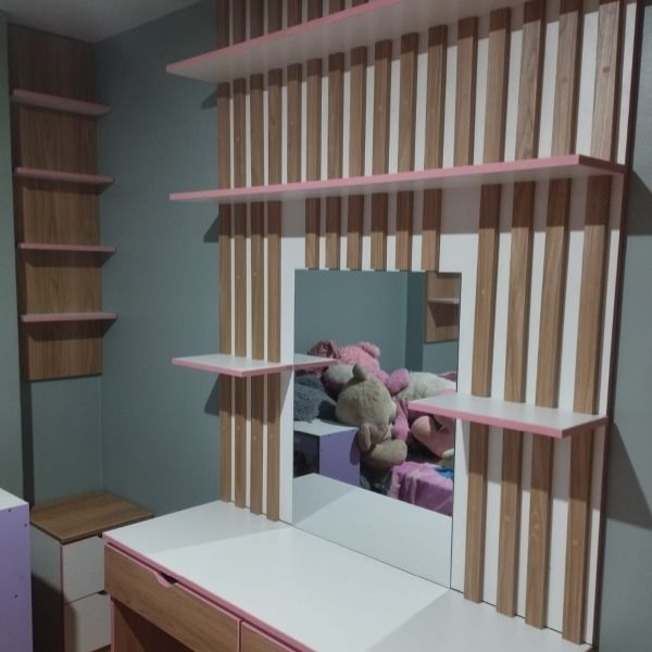 Un dormitorio de niña con una cómoda y un espejo.