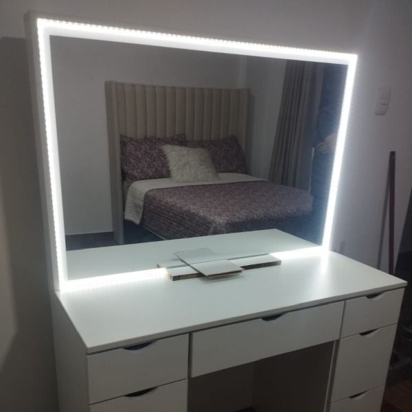 Un dormitorio con un gran espejo y una cama.