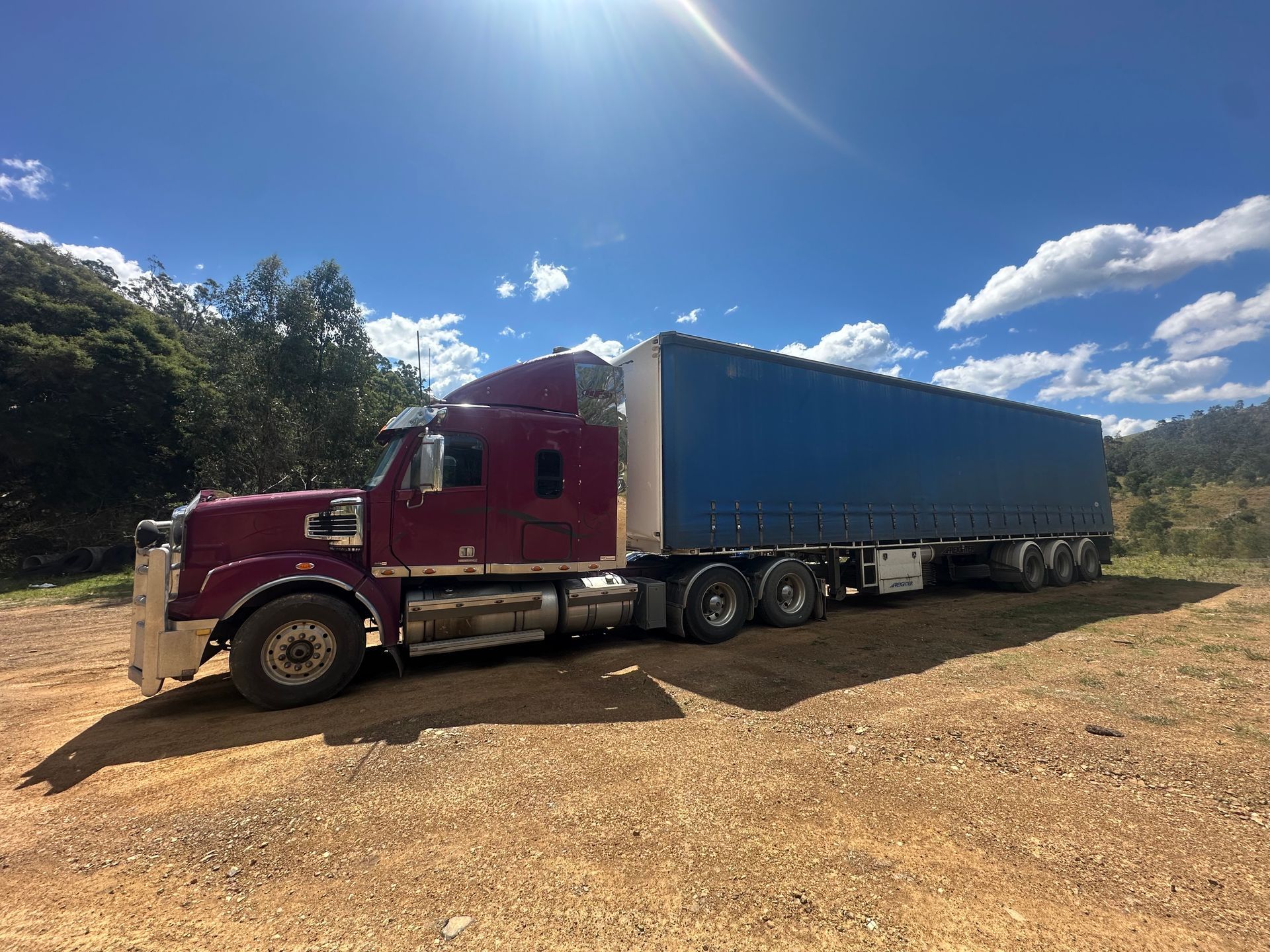 Blue Semi-truck With a Trailer on a Highway Against a Blue Sky — D & M Freighters Water In Stroud, NSW