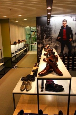 A store filled with lots of shoes and a picture of a man on the wall in the background.