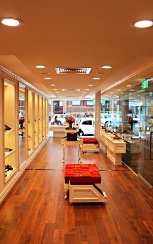 A shoe store with a lot of shelves and ottomans