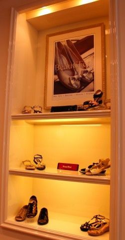 A shelf filled with shoes and a picture of shoes on it.