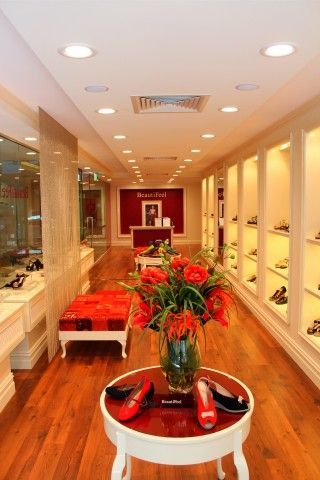 A shoe store with a vase of flowers on a table