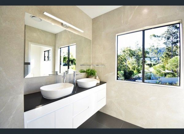A bathroom with two sinks and a large mirror