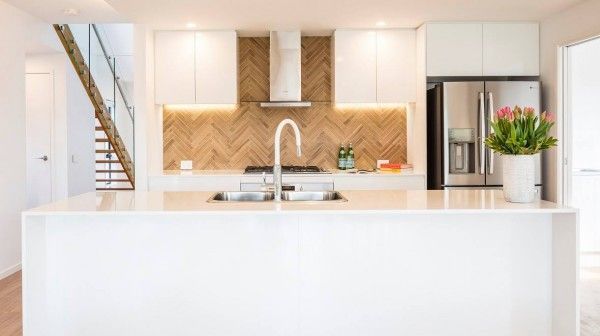 A kitchen with two sinks , a refrigerator , and a staircase.
