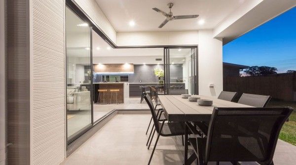 A patio with a table and chairs and a ceiling fan.