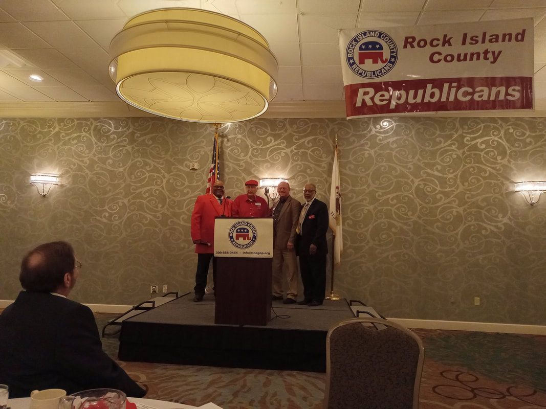 Person speaking at podium at Rock Island County Republicans event with banner overhead