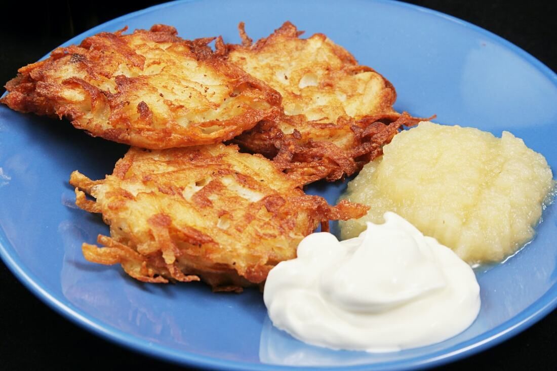 Blue plate with fried patties, applesauce, and a dollop of sour cream