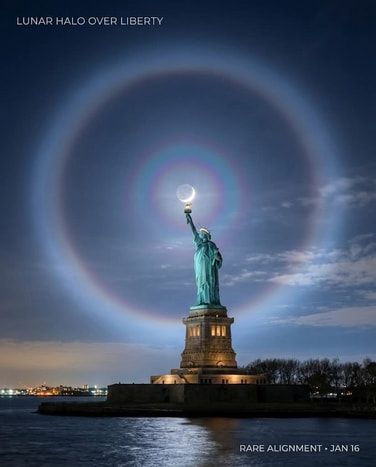 Statue of Liberty under a bright moon halo over New York harbor at dusk