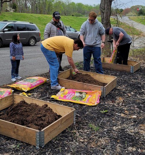 A group of people are working in a garden