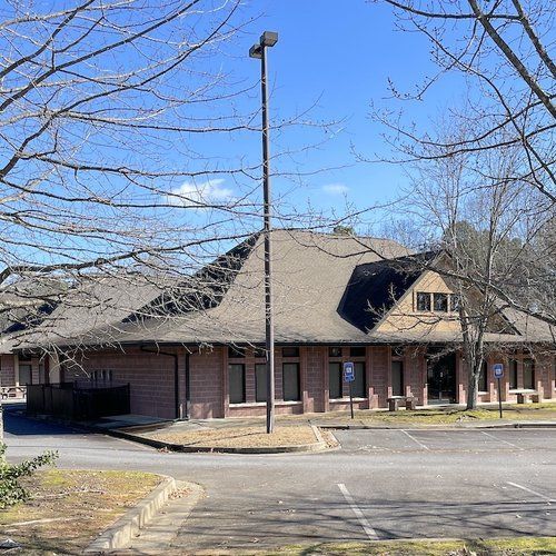 A large brick building with a parking lot in front of it.