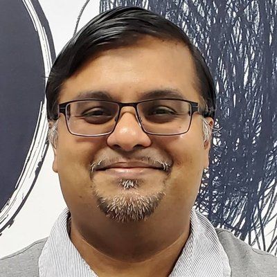 A man with glasses and a beard is smiling for the camera.