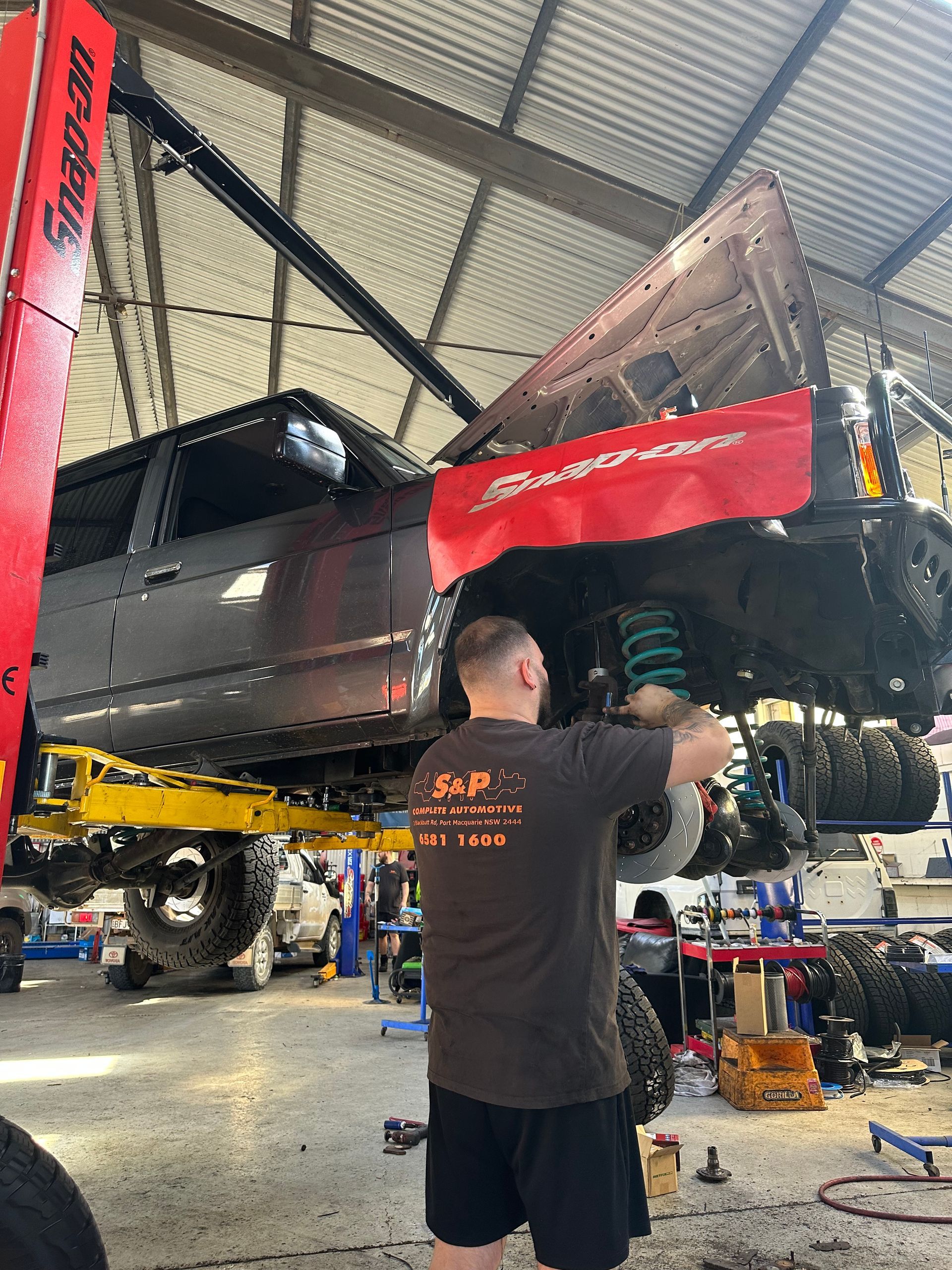 A Truck with Grizzly Premium Logo on A Lift in A Garage — S&P Complete Automotive in Port Macquarie, NSW
