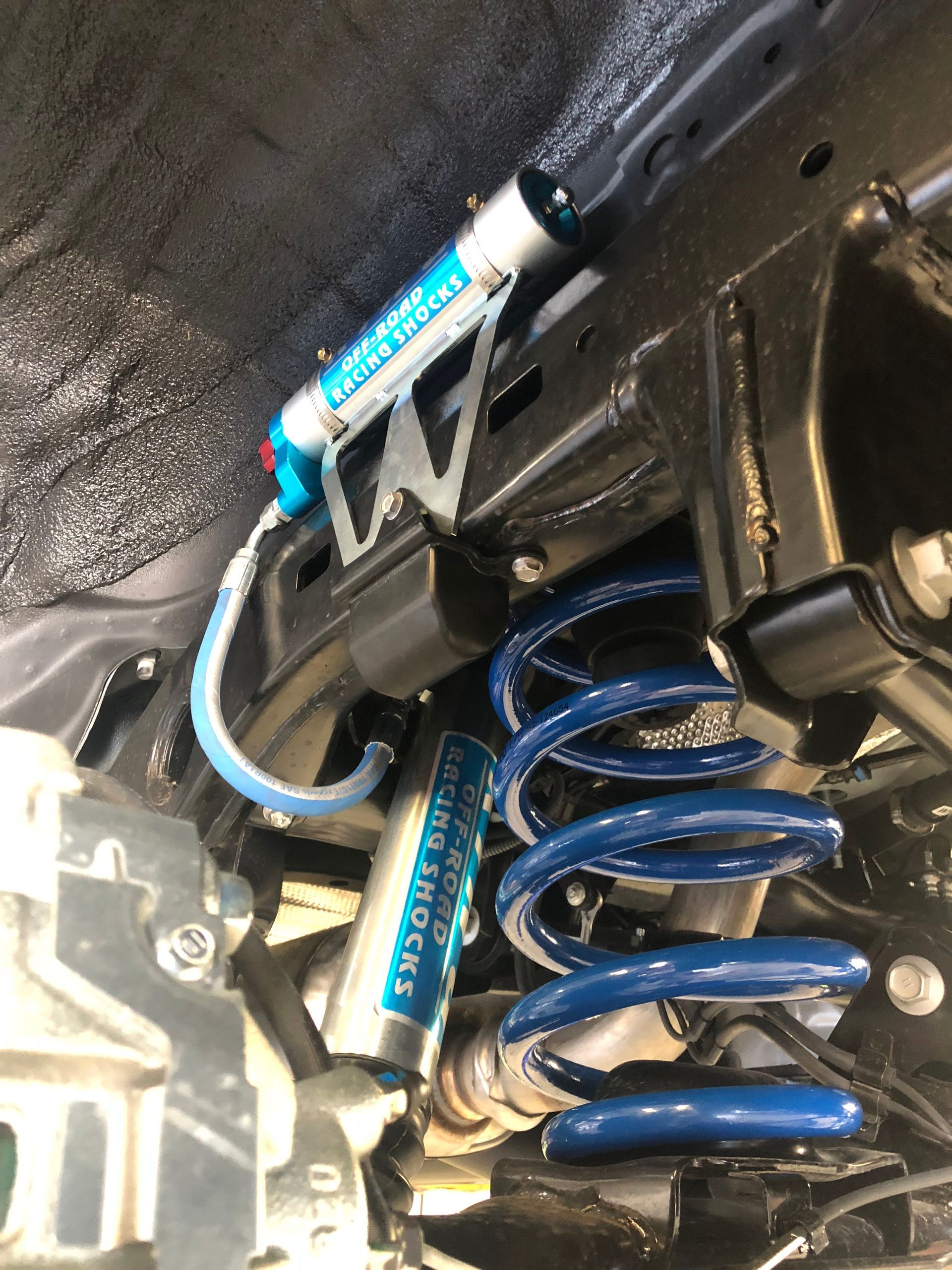 Blue coil spring and shock absorber on a vehicle's suspension — S&P Complete Automotive in Port Macquarie, NSW