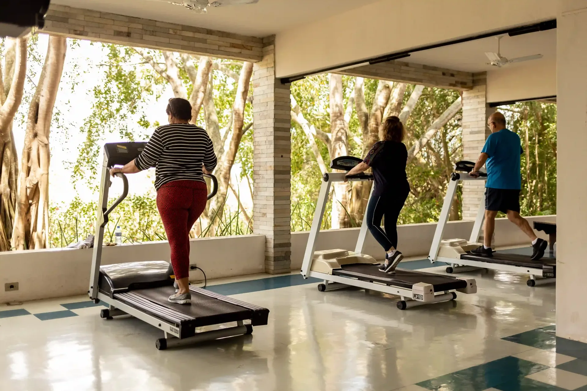 Um grupo de pessoas está correndo em esteiras em uma academia.-Oasis-Boutique-Hotel-e-Spa