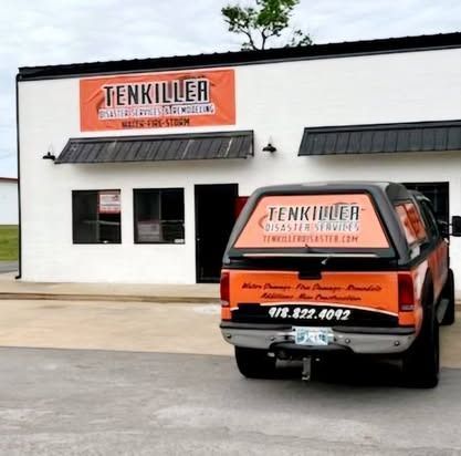 Orange-and-black Tenkiller business storefront with a matching pickup truck parked in front