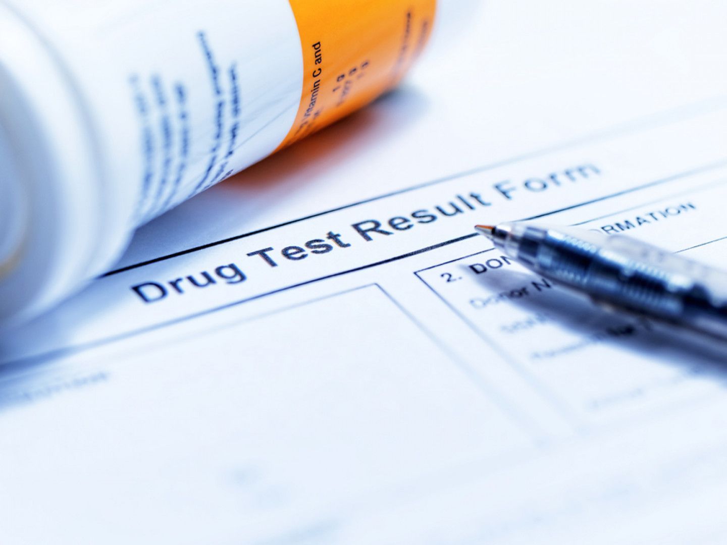 A pen is laying on top of a drug test result form