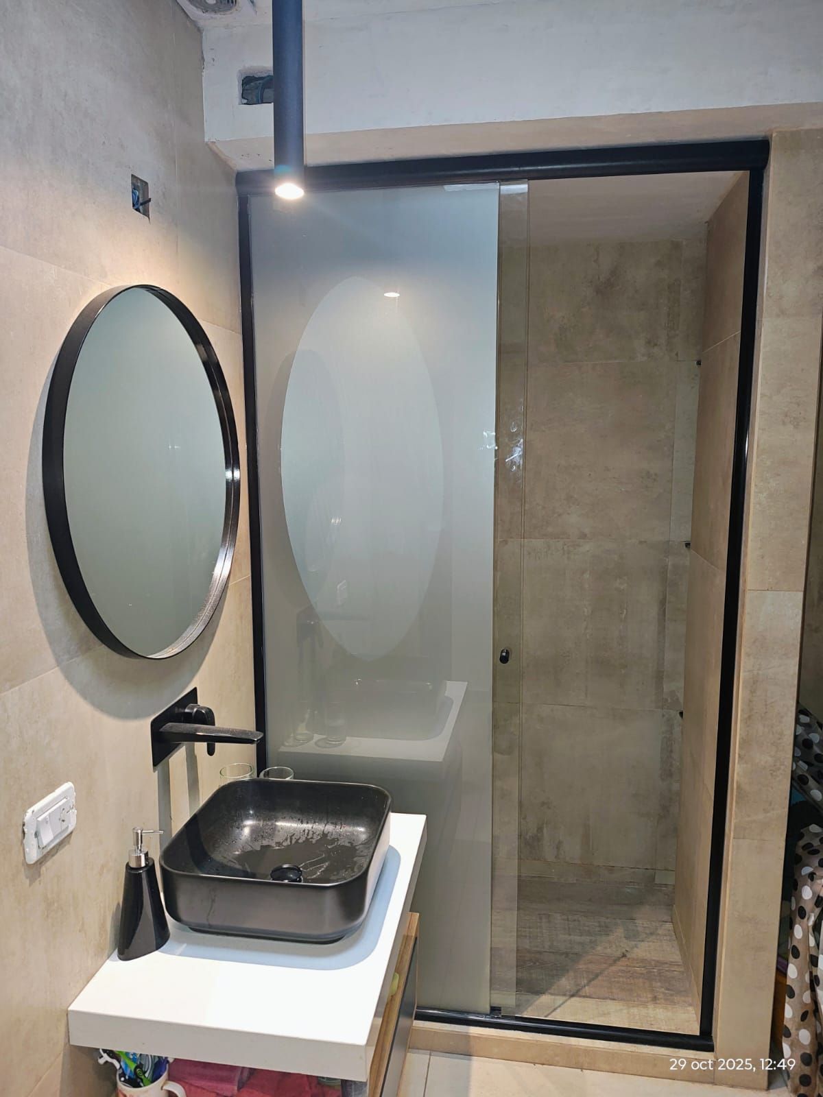 Baño moderno con ducha de cristal, azulejos grises y lavabo de sobremesa.