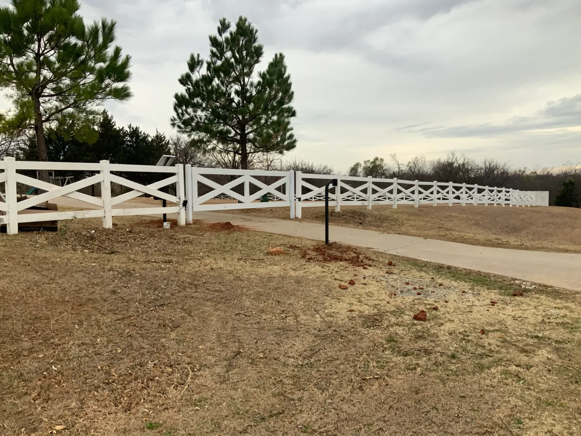 White vinyl ranch-style fence along a driveway — installed by Legacy Fence in Oklahoma City