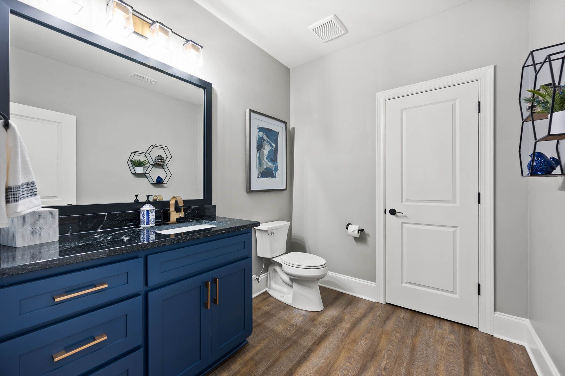a bathroom with blue cabinets and a toilet