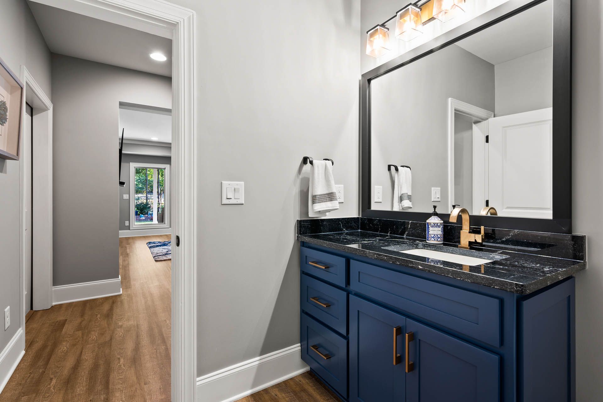 a bathroom with blue cabinets and black counter tops