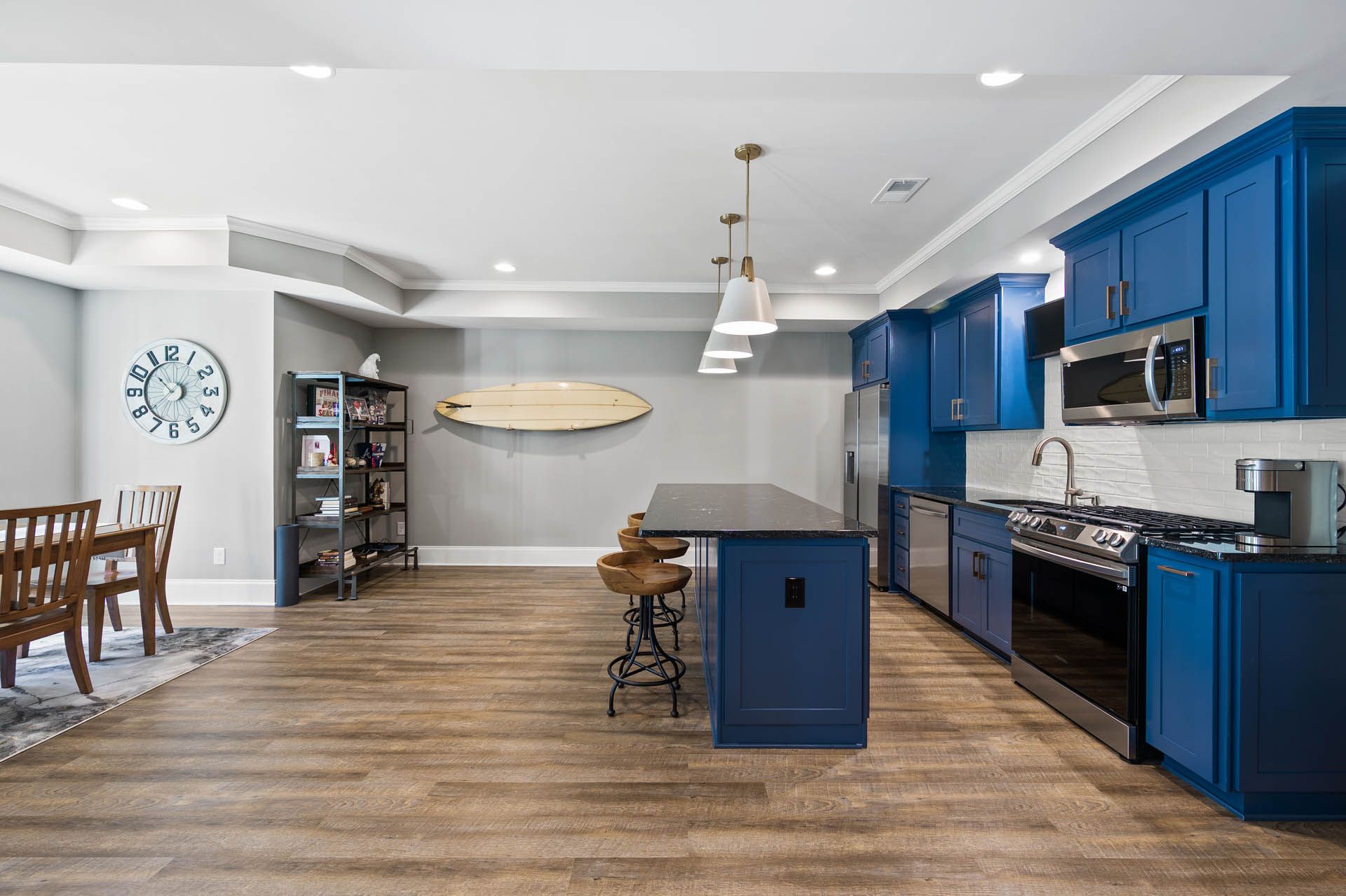a kitchen with blue cabinets and a surfboard on the wall