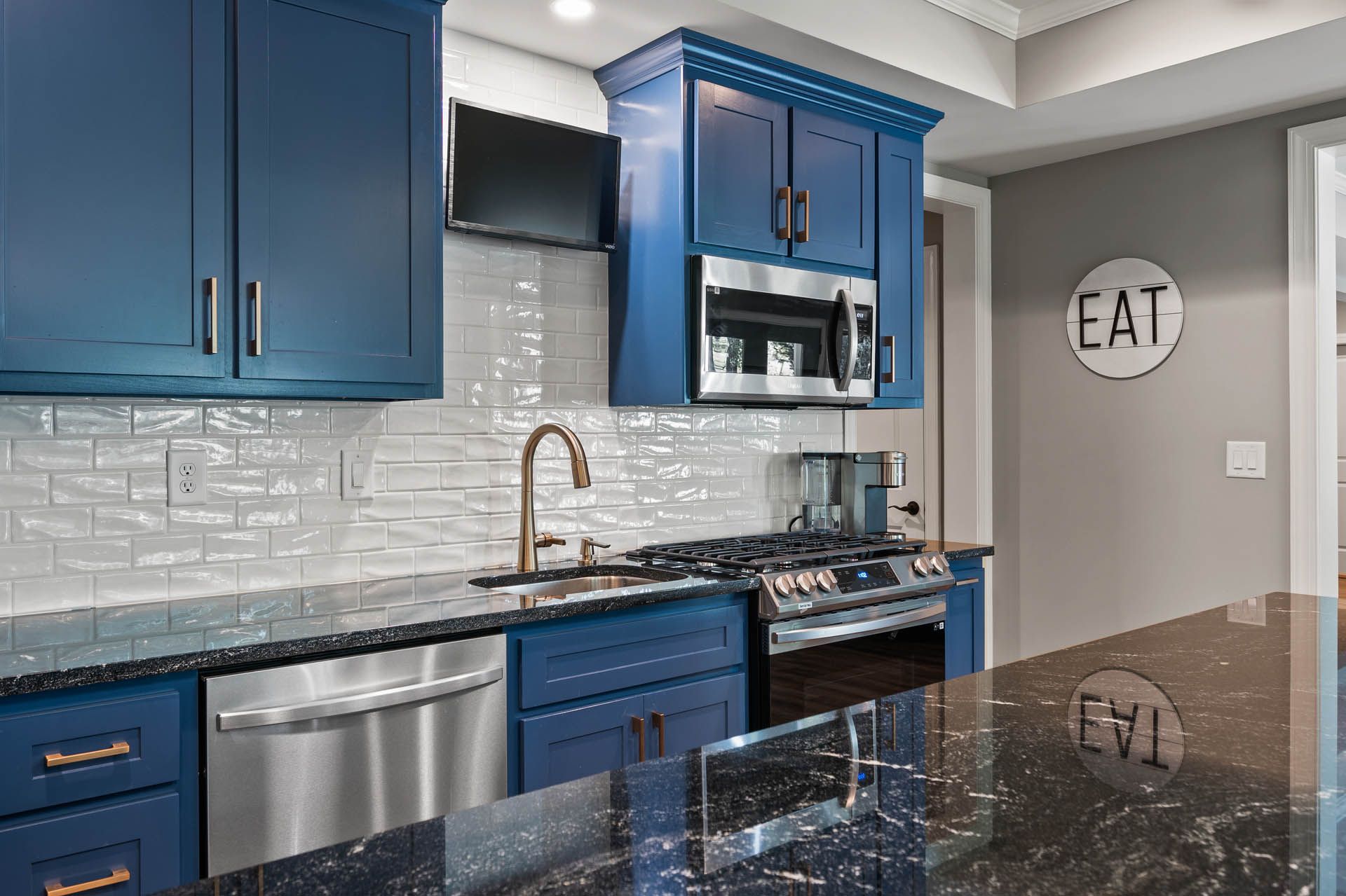 a kitchen with blue cabinets and a sign that says eat