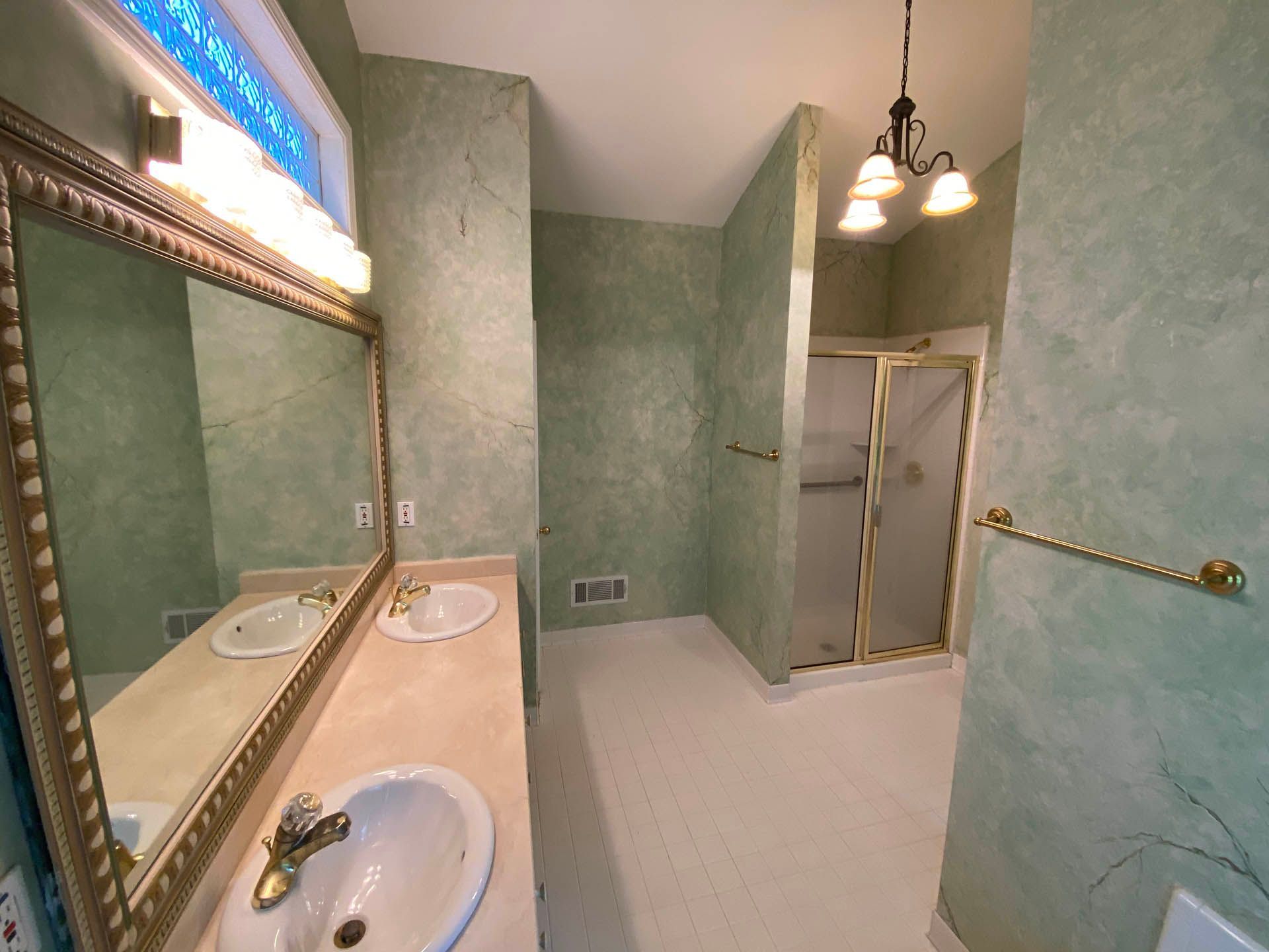 a bathroom with two sinks and a walk in shower
