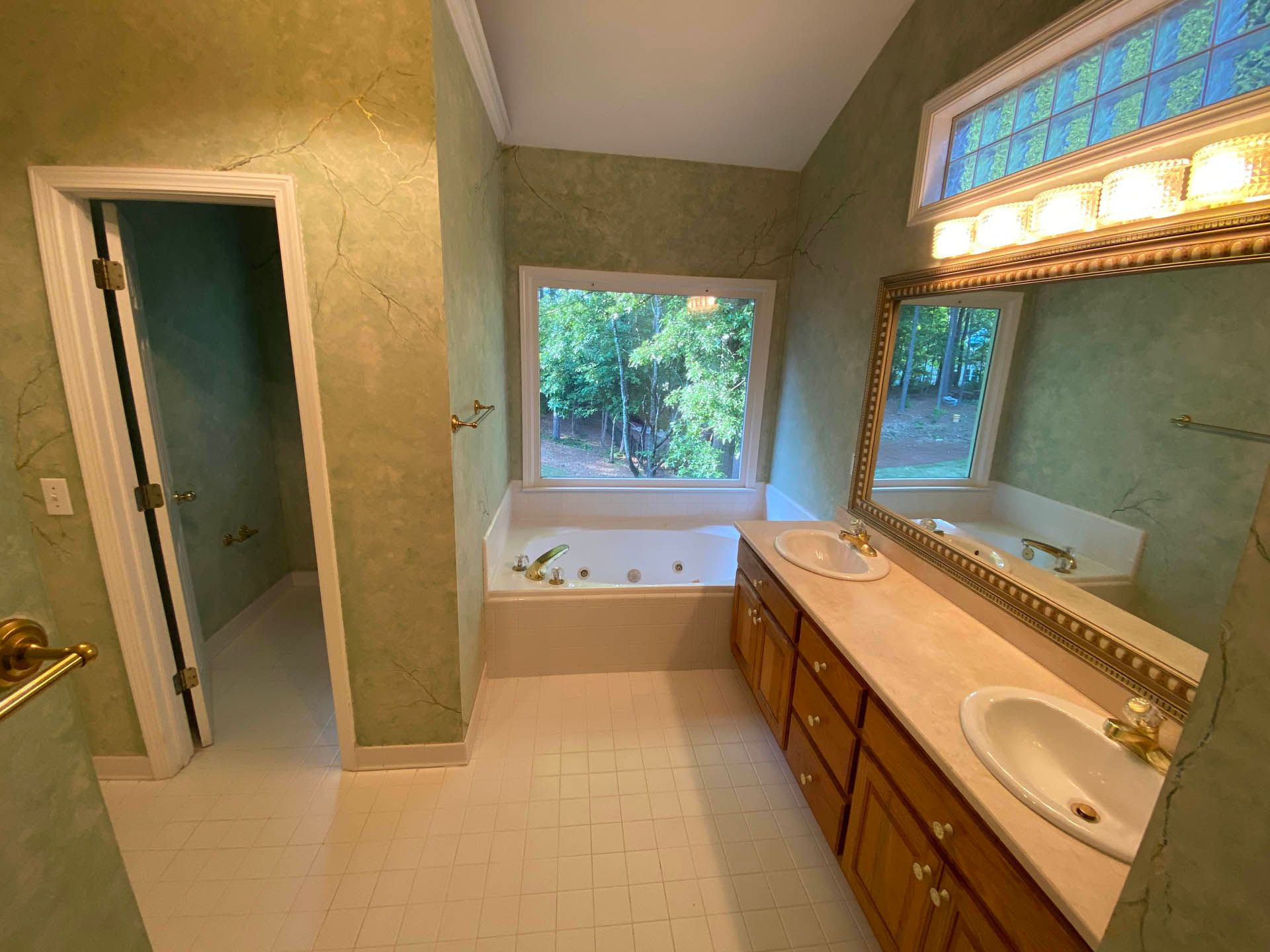 a bathroom with green walls and a jacuzzi tub