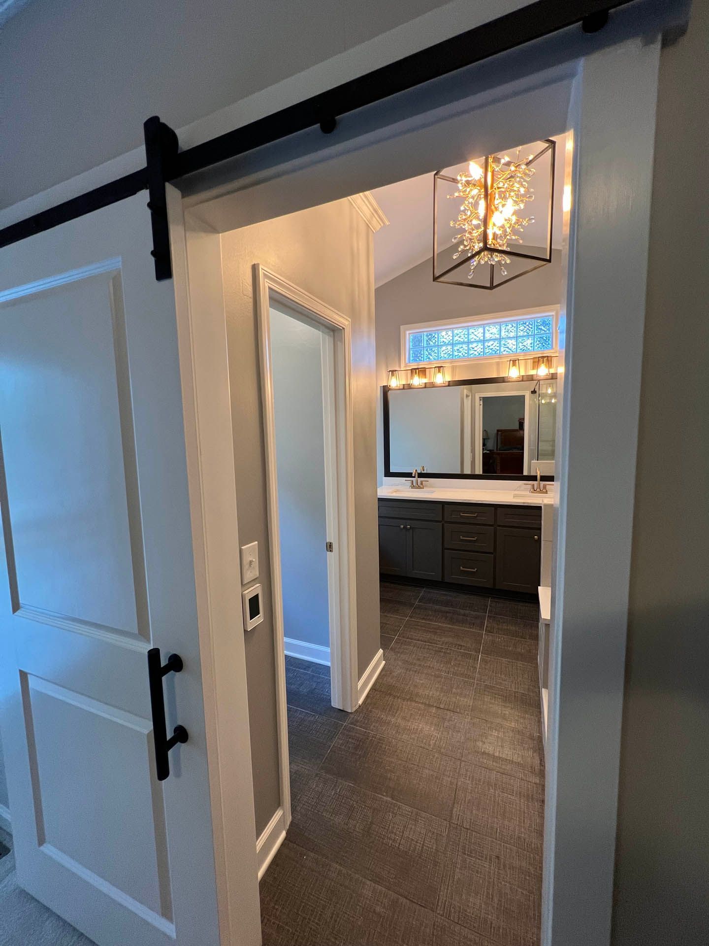 a bathroom with two sinks and a sliding barn door