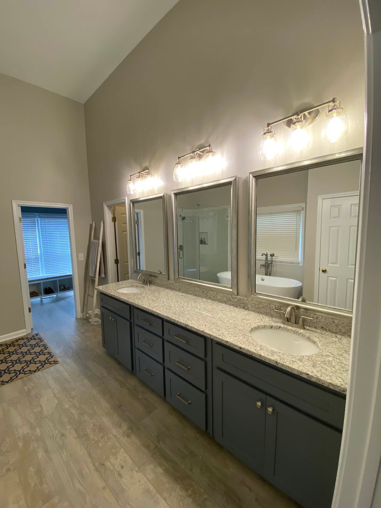 a bathroom with two sinks and three mirrors